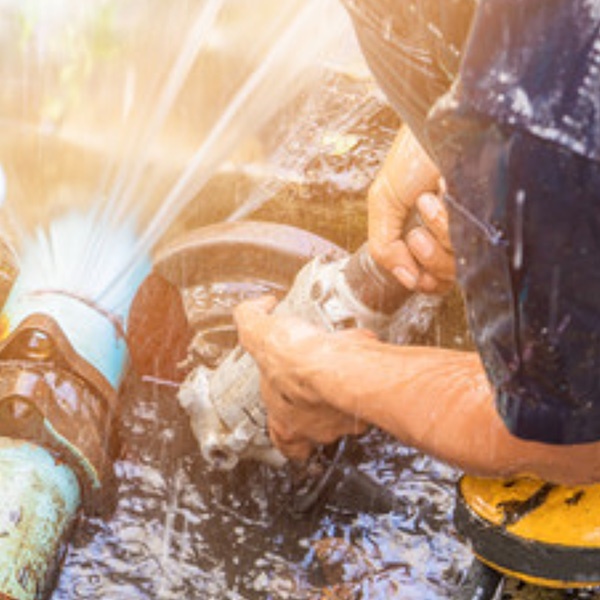 A technician repairing a backwater valve inside a basement floor drain at a house in Ottawa, ON