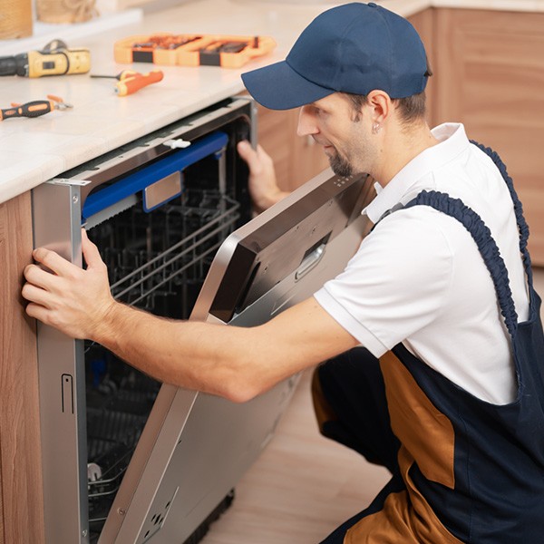 A technician is installing a built‑in dishwasher inside a residential kitchen in Ottawa, ON